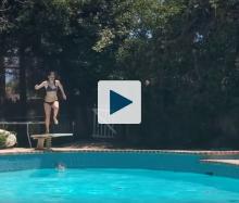 Woman jumping from diving board