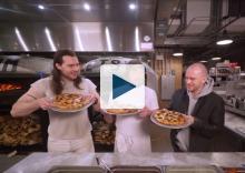 Three men holding pizzas
