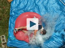 Dan falling onto giant water balloon